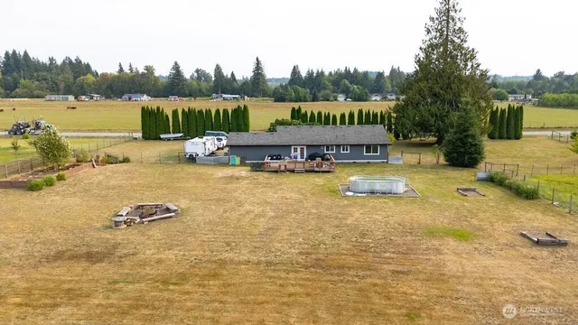 a view of a swimming pool with a patio and a yard with lake view