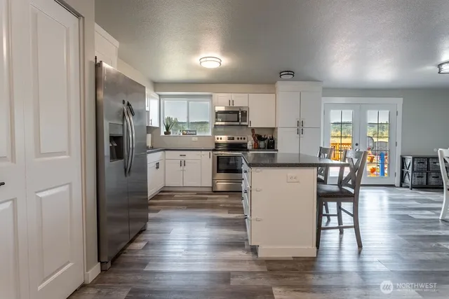 a kitchen with kitchen island white cabinets and stainless steel appliances