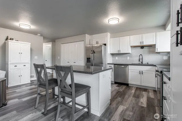 a kitchen with a table chairs microwave and cabinets