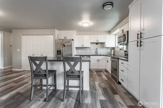 a kitchen with white cabinets and stainless steel appliances