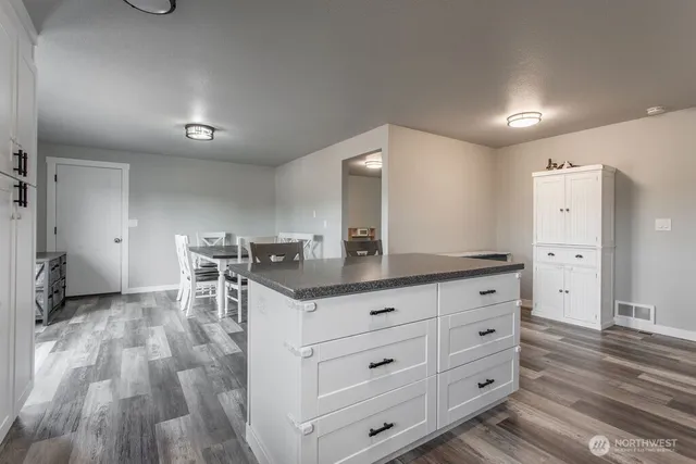a kitchen with granite countertop cabinets and chair