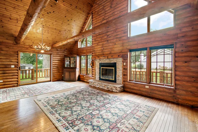 an empty room with floor to ceiling windows and fireplace