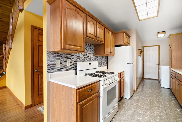 a kitchen with stainless steel appliances granite countertop a sink a stove and a wooden floors