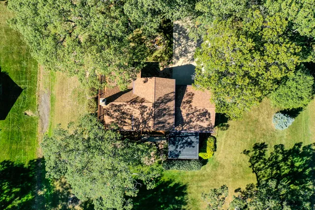 an aerial view of ocean and residential houses with outdoor space