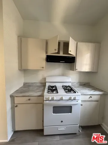 a kitchen with white cabinets and white appliances