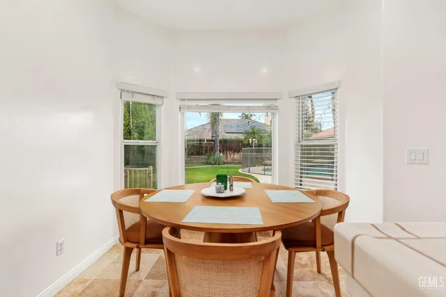 a dining room with furniture and a potted plant
