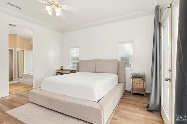 a spacious bedroom with a bed and a chandelier