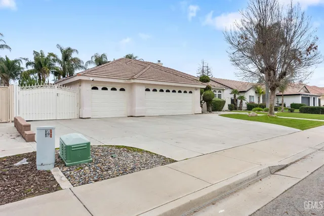 a white house that has tree in front of it