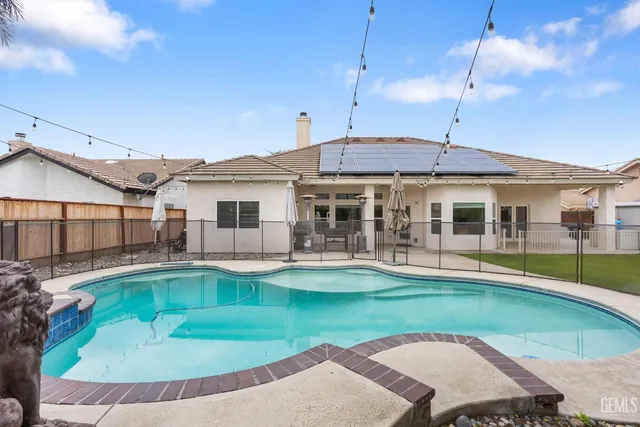 a view of house with swimming pool and sitting area