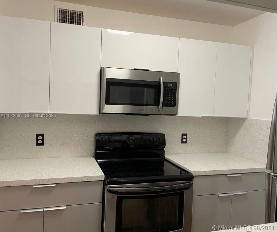 4421 West McNab Road, Unit 20 Pompano Beach, FL 33069 - Photo 6 of 14 a kitchen with a stove and a microwave