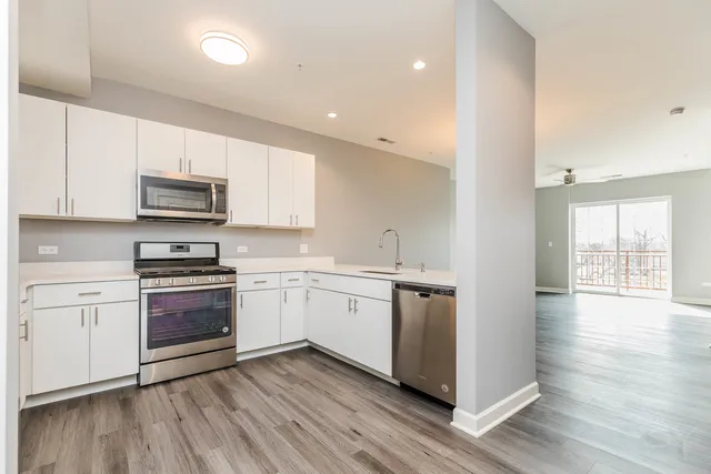 a kitchen with granite countertop white cabinets and stainless steel appliances