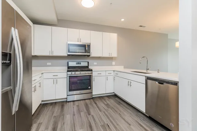 a kitchen with a sink stainless steel appliances and white cabinets