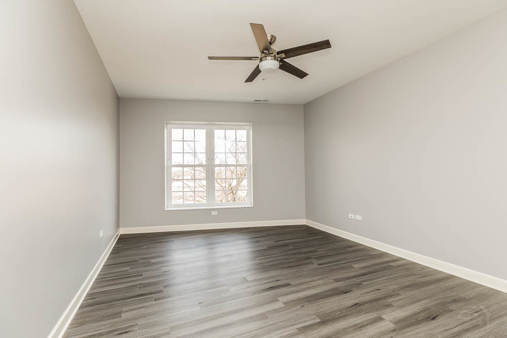 1312 Shermer Road, Unit 301 Northbrook, IL 60062 - Photo 6 of 10 an empty room with wooden floor fan and windows