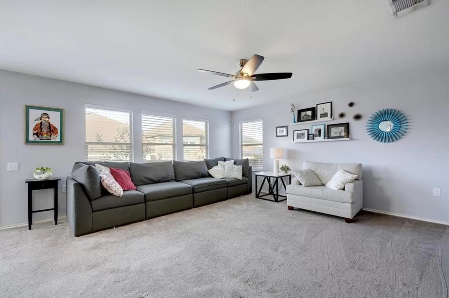 9016 Ridgewell Road Austin, TX 78747 - Photo 14 of 30 A comfortable living space boasts abundant natural light and soft, neutral carpeting.