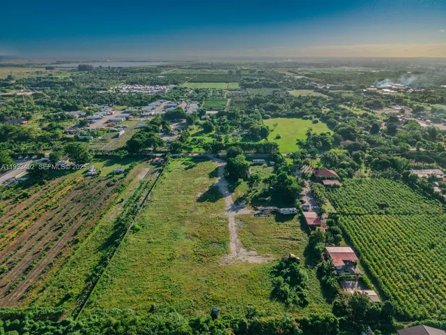 an aerial view of residential houses with outdoor space and trees
