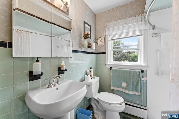 a bathroom with a sink a toilet and mirror