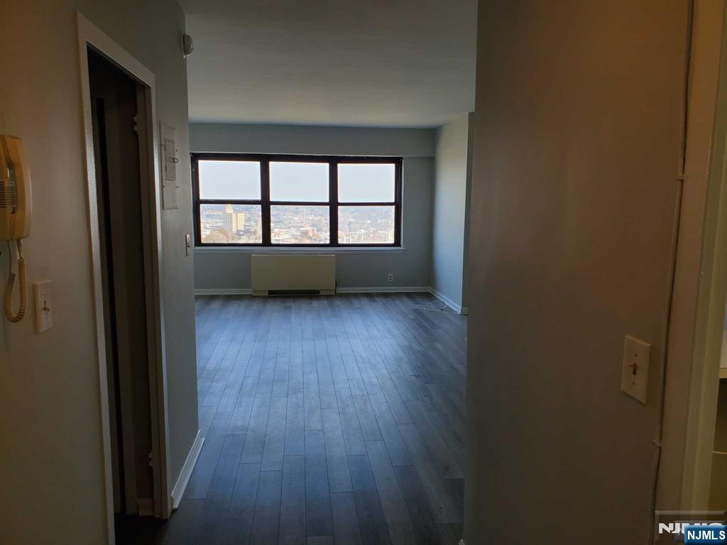 285 Aycrigg Avenue, Unit 22C Passaic, NJ 07055 - Photo 7 of 14 wooden floor in an empty room with a window