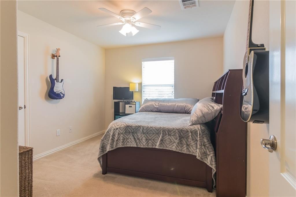 252 Pond View Pass Buda, TX 78610 - Photo 21 of 37 a bedroom with a bed and a chandelier