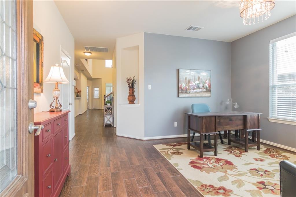 252 Pond View Pass Buda, TX 78610 - Photo 3 of 37 a dining room with wooden floor and a chandelier