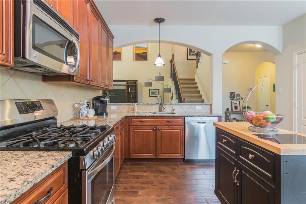252 Pond View Pass Buda, TX 78610 - Photo 8 of 37 a kitchen with stainless steel appliances granite countertop a stove a sink and a microwave