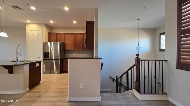 a kitchen with stainless steel appliances granite countertop a refrigerator a stove and a sink