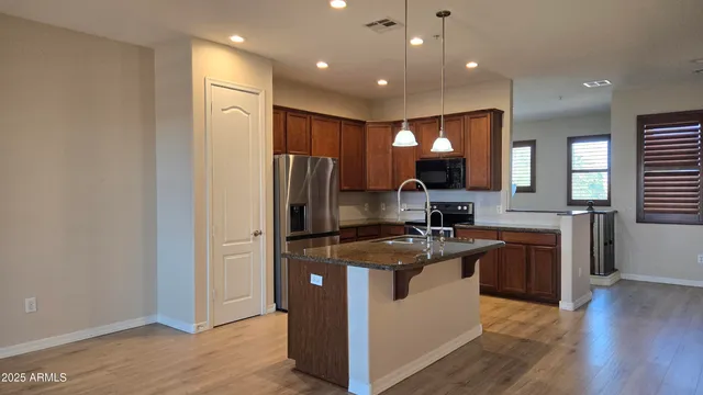a kitchen with kitchen island stainless steel appliances sink stove refrigerator and microwave