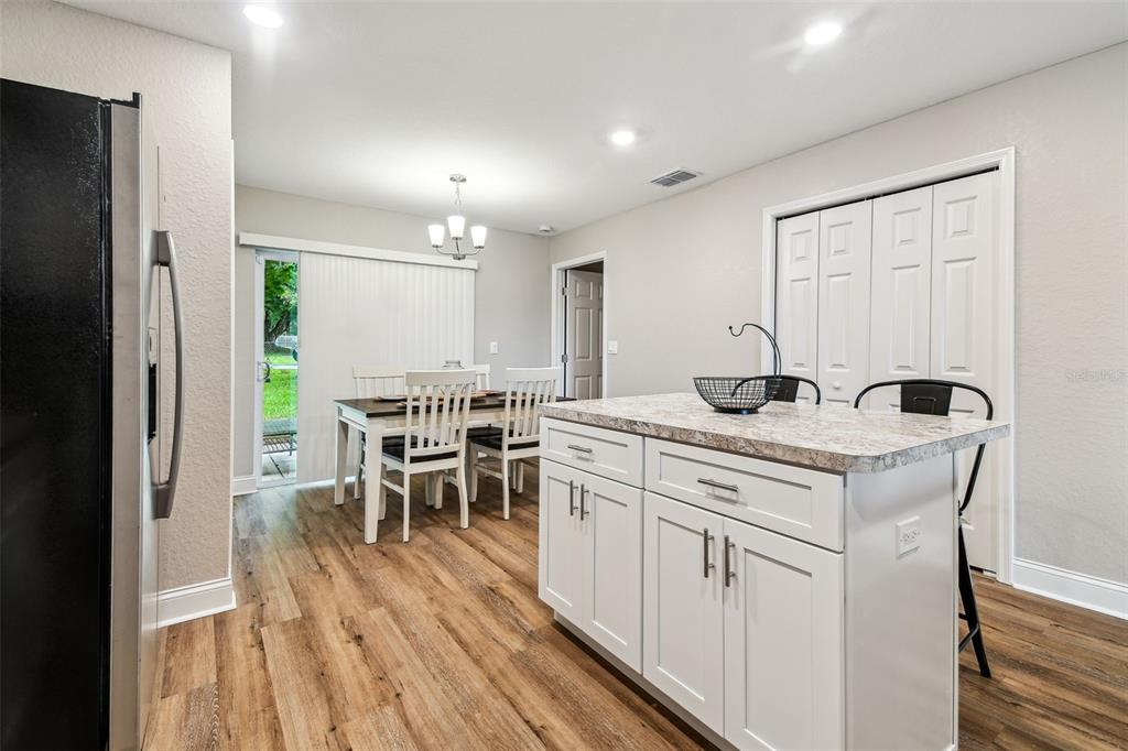 524 Carroll Avenue Lakeland, FL 33815 - Photo 12 of 33 a kitchen with a table chairs refrigerator and cabinets