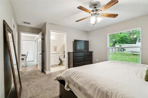 a spacious bedroom with a bed and a television