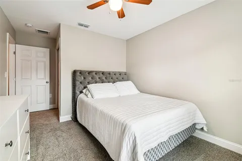 a bedroom with a bed and a ceiling fan