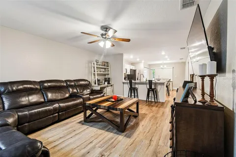a living room with furniture a ceiling fan and a rug