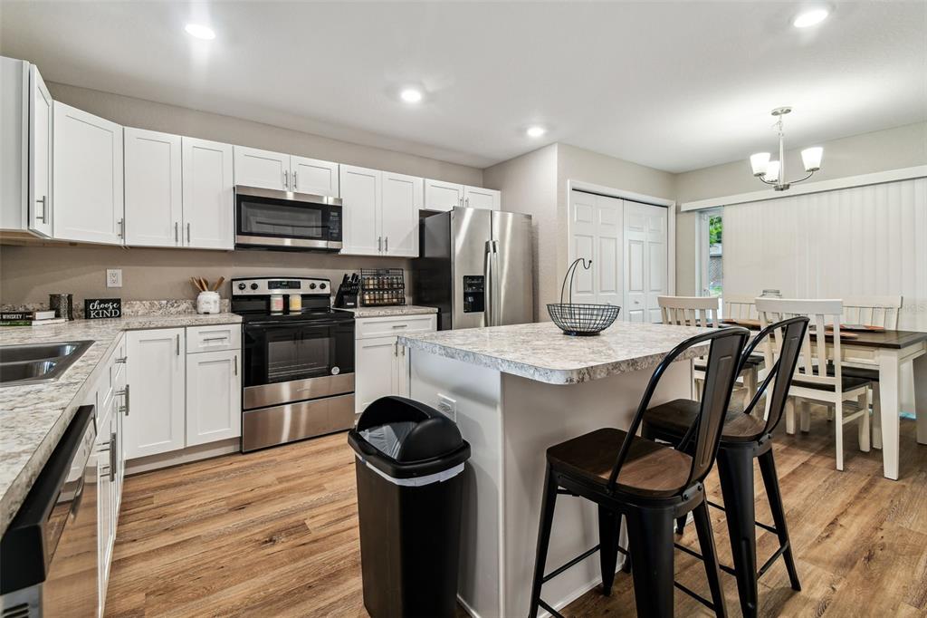 524 Carroll Avenue Lakeland, FL 33815 - Photo 10 of 33 a kitchen with stainless steel appliances kitchen island granite countertop a table chairs sink and cabinets