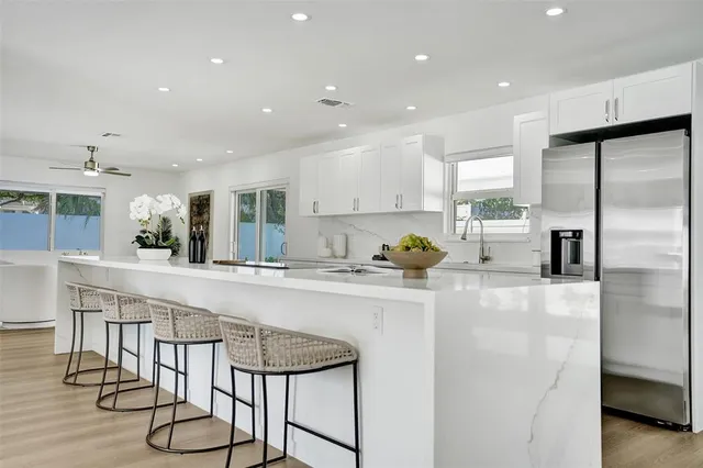 a large white kitchen with stainless steel appliances