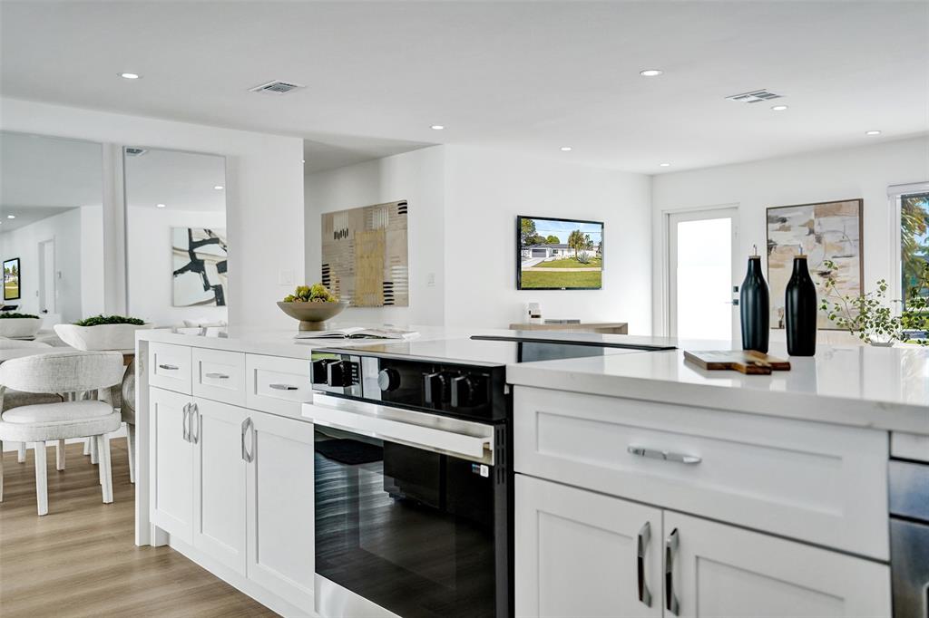 699 Northeast 70th Street Boca Raton, FL 33487 - Photo 17 of 66 a kitchen with stainless steel appliances white cabinets and a granite counter tops