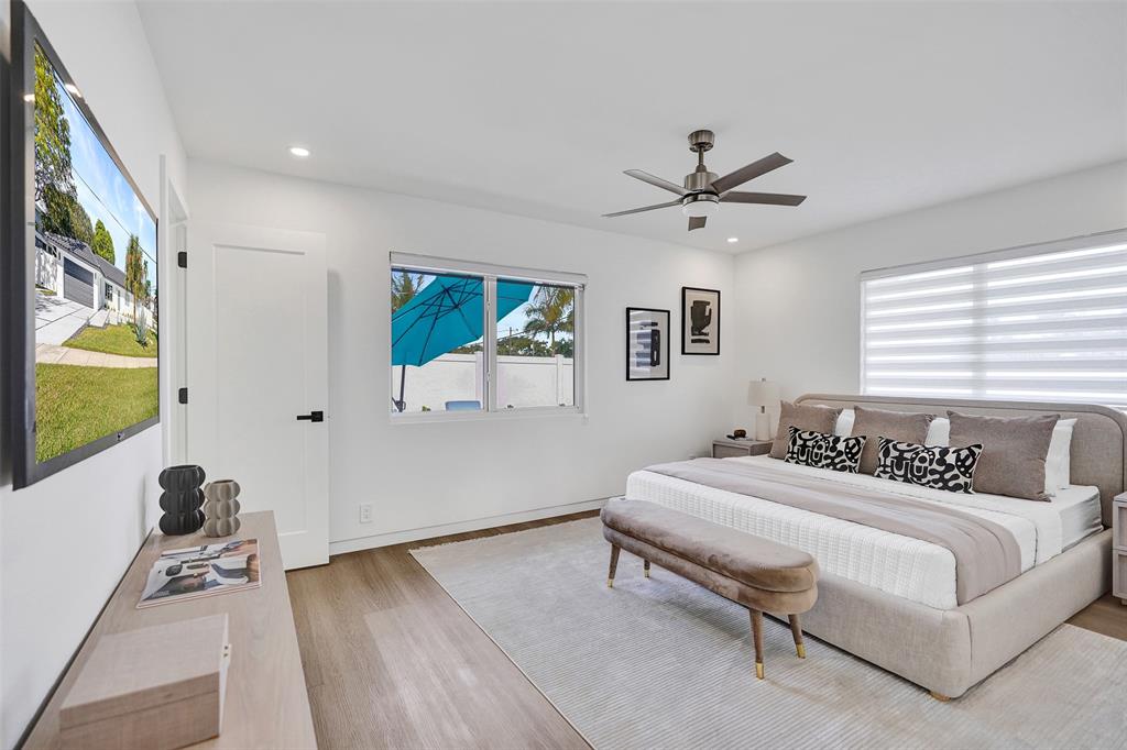 699 Northeast 70th Street Boca Raton, FL 33487 - Photo 31 of 66 a bedroom with a bed and a chandelier