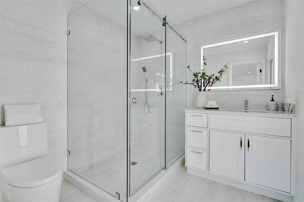 699 Northeast 70th Street Boca Raton, FL 33487 - Photo 34 of 66 a bathroom with a granite countertop sink a toilet and shower