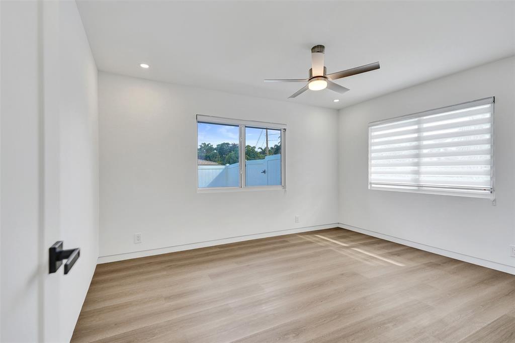 699 Northeast 70th Street Boca Raton, FL 33487 - Photo 36 of 66 an empty room with wooden floor ceiling fan and windows