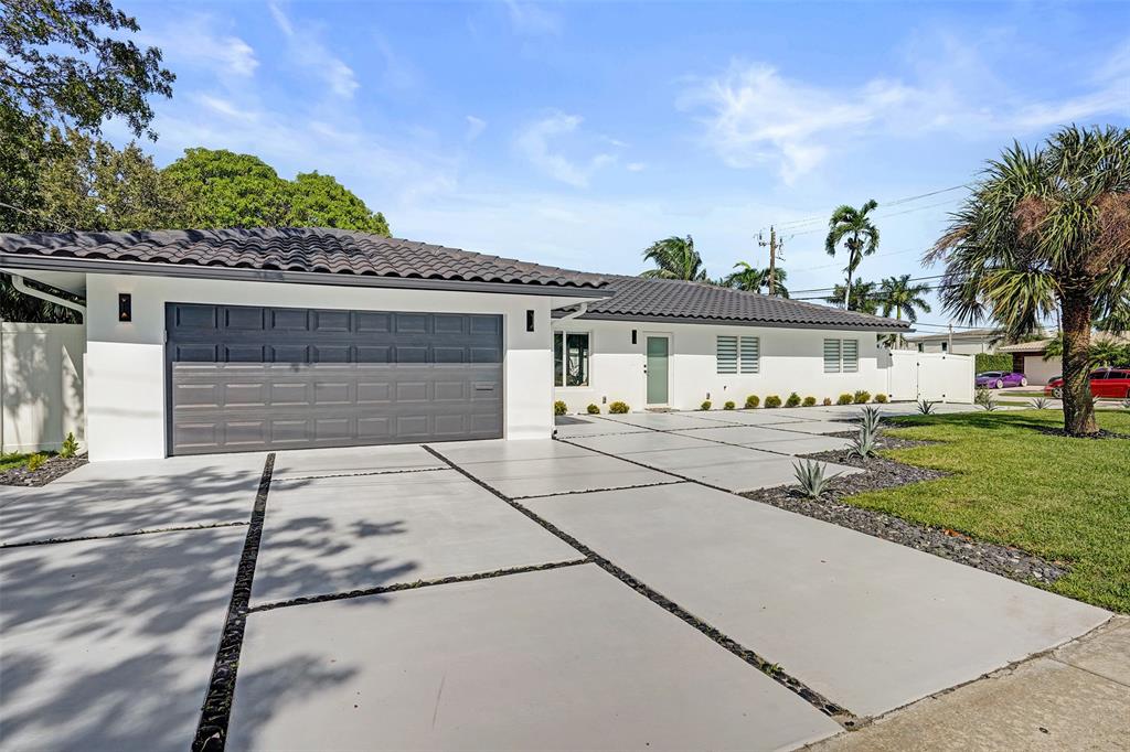 699 Northeast 70th Street Boca Raton, FL 33487 - Photo 4 of 66 a front view of a house with a garden and trees