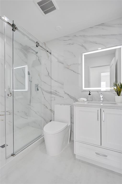 699 Northeast 70th Street Boca Raton, FL 33487 - Photo 42 of 66 a bathroom with a granite countertop sink a toilet and shower