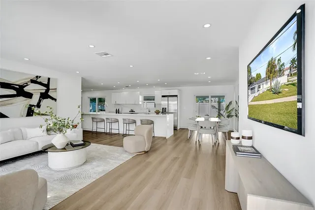 a kitchen with stainless steel appliances kitchen island granite countertop a stove a sink and a refrigerator with wooden floor