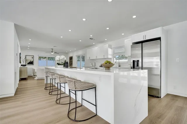 a large kitchen with stainless steel appliances granite countertop a lot of counter space and wooden floors