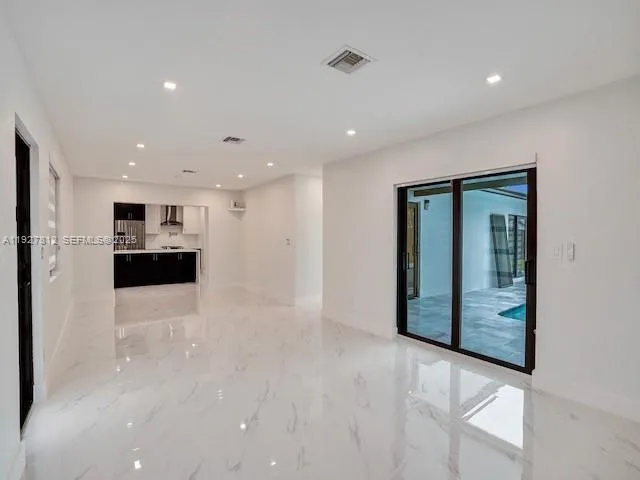 a view of kitchen with refrigerator and white cabinet
