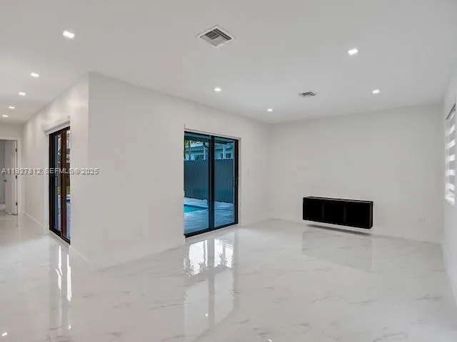 a living room with stainless steel appliances with furniture