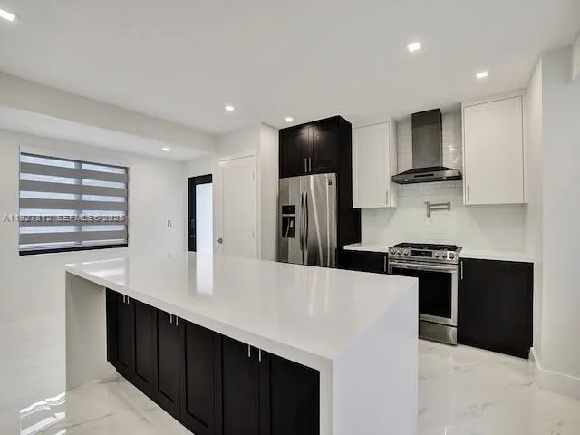 a kitchen with stainless steel appliances a refrigerator and a stove top oven