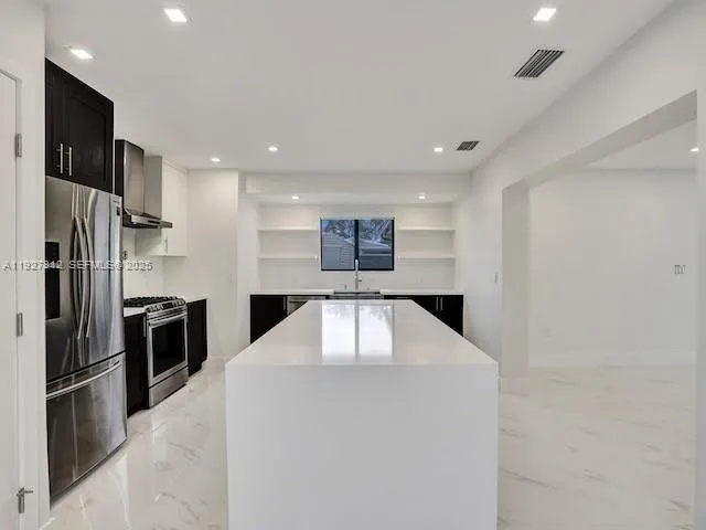 a kitchen with stainless steel appliances a refrigerator and a stove top oven