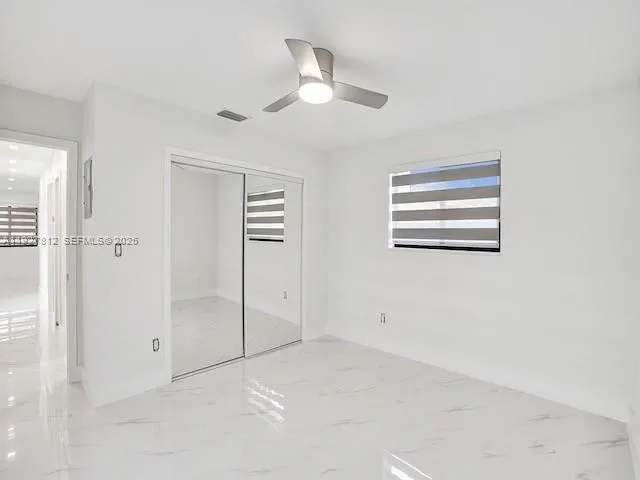 a view of a livingroom with a ceiling fan and window