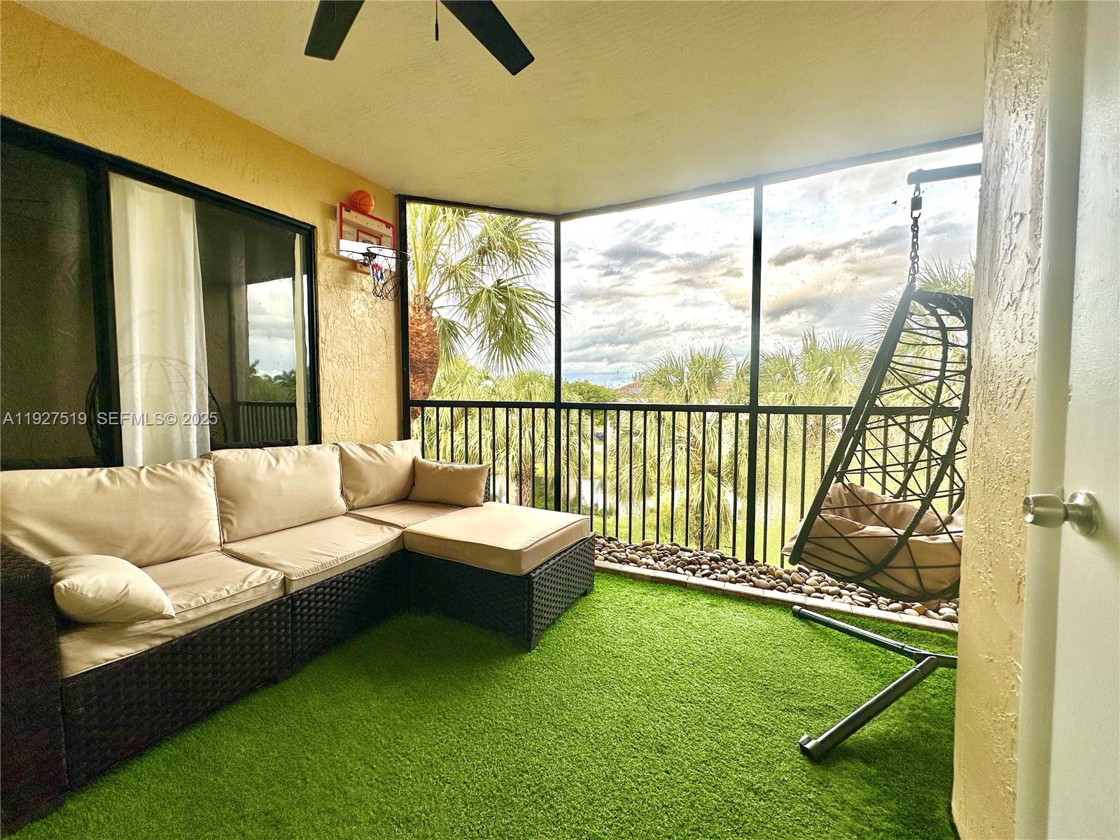 3470 Foxcroft Road, Unit 308 Miramar, FL 33025 - Photo 11 of 15 a living room with furniture and a floor to ceiling window