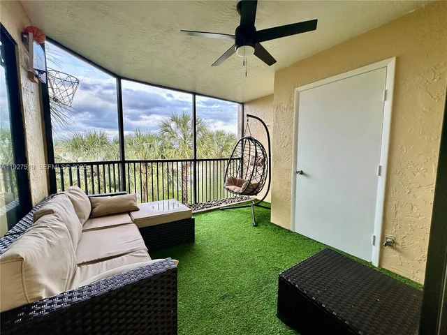 a living room with furniture and a floor to ceiling window