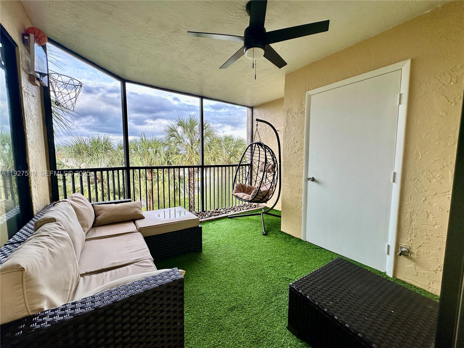 3470 Foxcroft Road, Unit 308 Miramar, FL 33025 - Photo 12 of 15 a living room with furniture and a floor to ceiling window