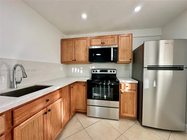 a kitchen with stainless steel appliances a refrigerator stove and microwave