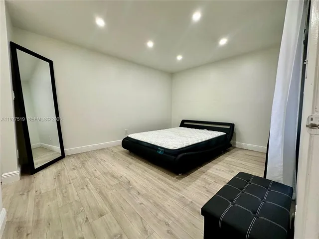 a bedroom with a bed and a mirror
